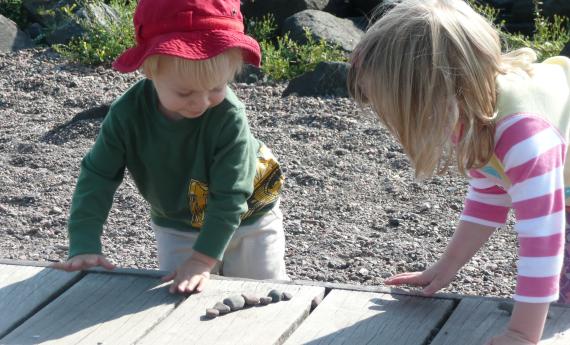 Two young children looking at rocks