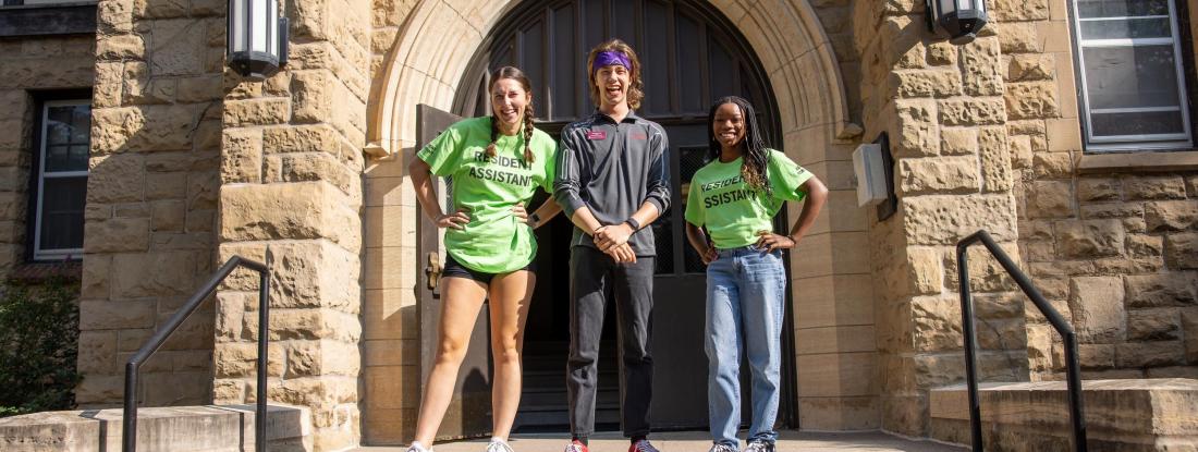 Three students in front of Manor Hall on move-in day