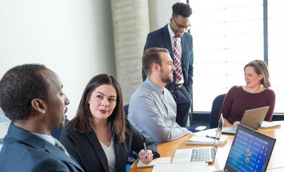 a group of Hamline MBA graduate students gathered in a conference room talking