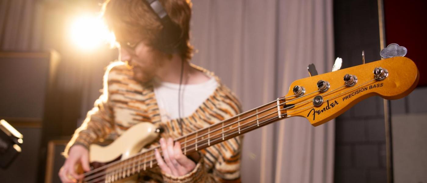 Student playing guitar in music production studio