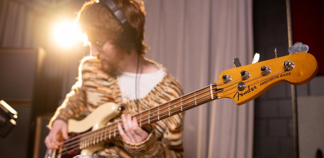 Student playing guitar in music production studio