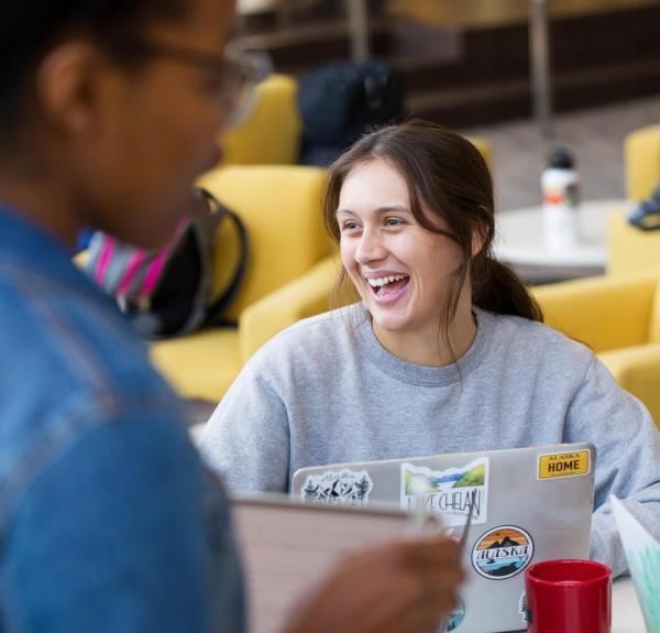 Student on laptop in Anderson, laughing